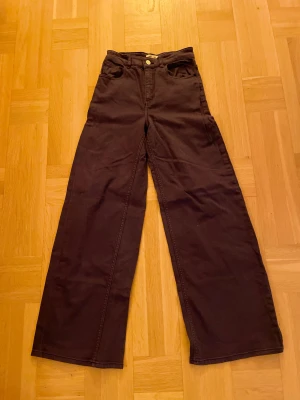 Mörklila wide jeans från Baum und Pferdgarten - Säljer ett par mörklila jeans från Baum und Pferdgarten med breda ben och hög midja. Klassisk femficksdesign. Materialet är kraftig bomull och passformen är loose med raka, vida ben. Perfekt för dig som gillar en cool och avslappnad stil. Strl 32. Hör gärna av er om ni har några frågor! MVH Tom