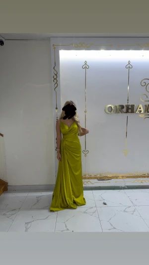 Lång limegrön klänning med omlott - Säljer en elegant långklänning i limegrönt med omlottdetalj och v-ringad hals. Klänningen har smala axelband och ett snyggt draperat fall som ger en lyxig känsla. Perfekt för dig som vill sticka ut med färg och stil på nästa bal eller fest.