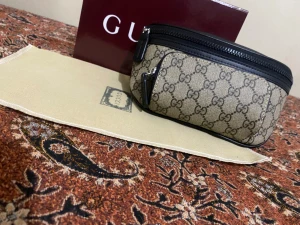 Beige Gucci axelväska med GG-mönster - Säljer en beige axelväska från Gucci med det klassiska GG-mönstret över hela väskan. Väskan har svarta detaljer, dragkedja upptill och en extra ficka framtill med dragkedja. Materialet är canvas med inslag av skinn. Perfekt storlek för det viktigaste och riktigt snygg design.