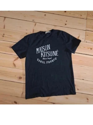 Svart Maison kitsuné t shirt  - Tjenare! Säljer nu min gamla maison kitsune T-shirt som knappt använts då den legat och skräpat i garderoben. Toppenskick, lite lätt urtvättad storlekslapp samt lite lätt sprucket tryck. Annars perfekt👍 Säljer för endast 499, T-shirts i samma modell går för runt 650. Hör av er vid fler frågor! Obs sitter som M