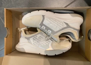 Vita EA7 Emporio Armani sneakers - Storlek är 37 1/3 men passar mig som även är 38 vanligtvis. Helt oanvänd, den har varit i sin låda sedan jag köpte den, men färgen har blivit gul av någon anledning, annars är den helt ny och oanvänd. Säljs inte längre. Kommer i original kartong.