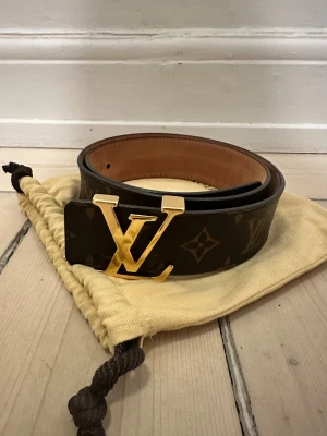 Louis Vuitton bälte - Skärp från Louis Vuitton. Köpt i deras butik i Köpenhamn. Något använd, med några små repor på logga och färgändringar i lädret på insidan. Annars i mycket bra skick!  Kopia på kvitto finns och original dustbag medföljer.  Storlek 80.