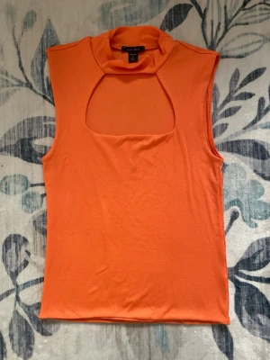 Orange keyhole topp - Orange topp/linne med polokrage och urskärning på bysten. Storlek: L. Märke: New Yorker. Bekvämt och stretchigt tyg. Använd en gång ute för en Velma-cosplay. Läs gärna bion innan köp!