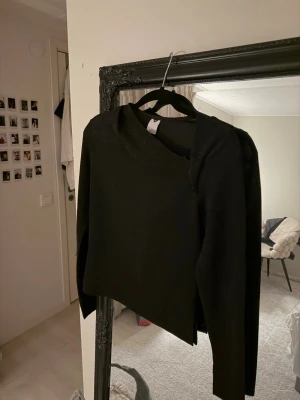Svart glittrig omlottopp XS - Säljer en svart omlottopp från Visual Clothing Project i storlek XS. Toppen har lång ärm och är glittrig med en snygg omlottdetalj framtill. Toppen är använd en nyår.