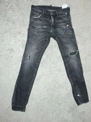 Svarta jeans från dsquared2 - Säljer ett par svarta skinny jeans från Dsq2 med slitna detaljer och hål på benen.  Hör av er vid frågor 