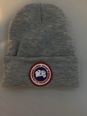 Grå Mössa från Canada Goose - En grå mössa från Canada Goose helt ny aldrig använd,väldigt varm och mysig