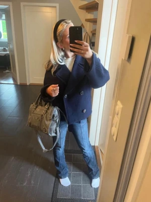 Mörkblå skepparkavaj med knappar - Säljer en mörkblå skepparkavaj med dubbelknäppning och bred krage. Jackan har en klassisk, lite boxig passform och är perfekt för dig som gillar en tidlös stil. Materialet känns rejält och passar bra till jeans eller kjol.