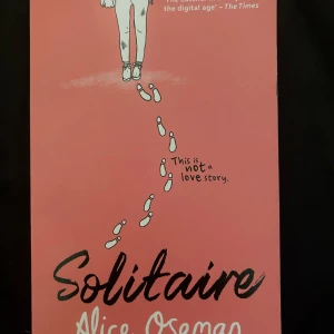 Solitaire - En ungdomsroman med rosa omslag, skriven av Alice Oseman. Boken har illustrationer av fotspår och en person i kjol på framsidan. Texten på baksidan beskriver huvudkaraktären Tori Spring och hennes syn på livet, vänskap och cynism.