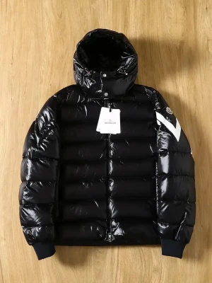 Svart pufferjacka från Moncler - Säljer en svart pufferjacka från Moncler med glansig finish och huva. Jackan har en vit detalj på ärmen, dragkedja framtill och ribbade muddar. Materialet är syntet och polyester, perfekt för kalla dagar. Stilsäker och riktigt fet jacka för vintern.