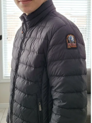 Svart dunjacka Parajumpers M - Säljer en svart dunjacka från Parajumpers i storlek M. Jackan är superlätt, har quiltad design, dragkedja framtill och flera fickor. Insidan är ljusbeige och jackan har en patch på ena ärmen. Perfekt för kalla dagar när du vill hålla stilen. Tyvärr har ena innerfickan lossnat lite men ingen man märket eller som syns.