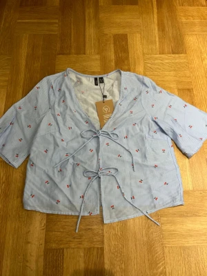 Fin blus🍒 - Fin blå vit randig blus med körsbär på. Helt ny med kappen kvar. Perfekt för sommaren!🍒☀️ säljes då den tyvärr var för liten 