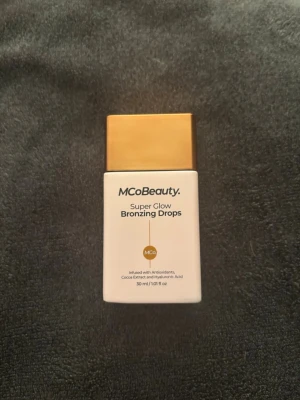 MCoBeauty Super Glow Bronzing Drops🫶🏻 - Super Glow Bronzing Drops från MCoBeauty i en stilren vit flaska med guldigt lock. Innehåller antioxidanter, kakaoextrakt och hyaluronsyra. Ger en naturlig gyllene glow och kan blandas med hudvård. Vegansk formula, 30 ml. Bara testad en gång, annars helt ny!🤍
