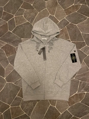 Stone Island Zip - En mycket fin helt ny zipper ifrån Stone Island. Tröjan har inga defekter därmed aldrig använd, fick den som present men tyckte inte om den. Sitter perfekt i storlek!                                              Priset kan diskuteras!