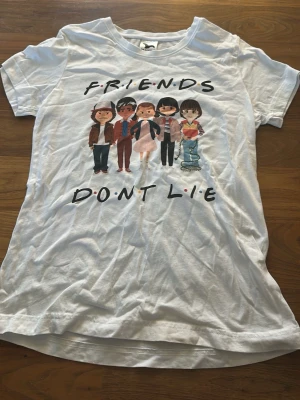 Friends don’t lie, stranger things - En stranger things T-shirt med ungdomarna på med citatet ”friends don’t lie”. Köptes second hand.