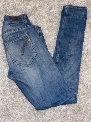 Blåa dondup jeans  - Säljer ett par lite schysstare dondup jeans i färgen blå. Jeansen är i dondups George modell och alltså skinny fitt. Jeansen är i storlek 29.  Notera att de ej sitter så skinny utan mer slim. Jeansen har några feta slitningar här och var. Hör av dig vid frågor eller funderingar! 