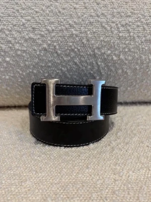 H-bälte - Ett svart H-bälte perfekt för dig som gillar mode och stil, bältet har ett H med färgen silver och är ett fint märke och ett välkänt märke från Frankrike Paris. Kom dm för eventuella frågor 🧐pris kan diskuteras 💯. 