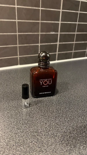 Stronger With You Parfum - Stonger With You Parfum- intensiv och maskulin doft med en varm blandning av kryddig rosépeppar, aromatisk lavendel och djup, läderaktig vanilj med kastanje-ackord som ger ett sensuellt och självsäkert intryck.  ￼ 📦 Perfekt prov/test på 2 ml 