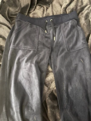 Mörkblå Juicy byxor - Mysiga mörkblå mysbyxor i mjukt material med bred resår i midjan och snörning framtill. Byxorna har stora fickor fram och bakfickor med lock och knappar. Perfekta för chill eller slappa dagar. Ser av någon anledning ut gråa på kameran men i verkligheten är de mörkblå! 🙌💕