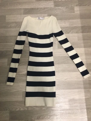 Randig ribbad klänning från Zara - Säljer en ribbad, långärmad klänning från Zara med breda mörkblå och vita ränder. Klänningen är figurnära och har en klassisk rund halsringning. Perfekt för dig som gillar en enkel men snygg look.