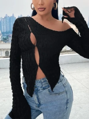 Svart asymmetrisk långärmad topp - Säljer en svart långärmad topp med asymmetrisk design och offshoulder-skärning. Toppen har ett vågigt, strukturerat tyg och coola utskärningar framtill. Passformen är tight och toppen är croppad med spetsig nederkant.