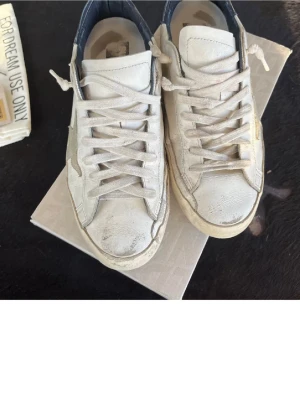 Golden Goose Superstar sneakers vit/blå - Allt og finns, box, dustbag, lappar samt digitalt kvittot från golden goose hemsida. Använda men har mycket kvar att ge! Bara att skriva för fler bilder 