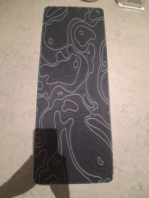 Musmatta svart - Säljer en svart dunväst med ett unikt abstrakt mönster i vitt. Västen har en modern look och passar perfekt för dig som vill sticka ut. Den är lätt och smidig att bära och har en stilren design.