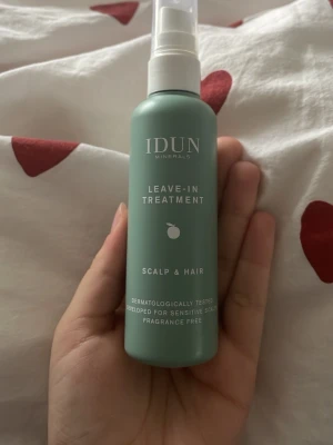 IDUN Minerals Leave-In Treatment - Grön sprayflaska med IDUN Minerals Leave-In Treatment för hårbotten och hår. Vegansk, parfymfri och dermatologiskt testad. Flaskan är på 100 ml och tillverkad av återvunnen plast. Perfekt för dig som vill ha återfuktat hår utan doft. Ca 70ml kvar