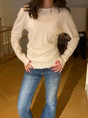 Vit långärmad tjocktröja i merinoull - En enkel och stilren beige långärmad tröja i mjuk merinoull . Tröjan har rund halsringning och normal passform, perfekt att matcha med jeans eller kjol för en clean look. Kolla in mina andra annonser!💕