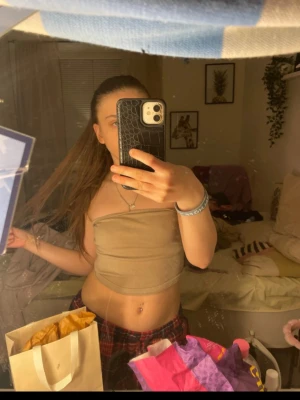 Beige ribbad tubtopp från Gina Tricot - Säljer en beige ribbad tubtopp från Gina Tricot i storlek S. Toppen är bandeau-modell och ärmlös, perfekt för varma dagar eller att styla med lager. Mjuk och stretchig med en enkel, clean look.