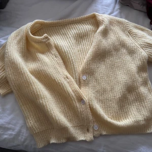 Ljusgul stickad kortärmad kofta - Säljer en söt ljusgul stickad kofta med korta ärmar och v-ringning.💛