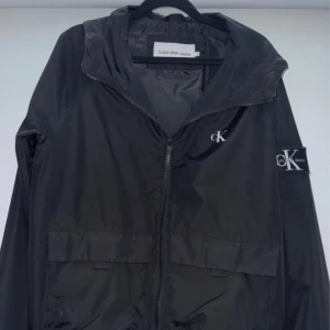 Calvin Klein Svart Vindjacka - En vindjacka från Calvin Klein som inte har några spår av användning eller skador.