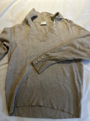 Beige stickad tröja från Vila - Säljer en beige stickad tröja från Vila i storlek S. Tröjan har v-ringning, långa ärmar och ribbade muddar. Fina pärldetaljer vid ärmsluten ger en extra touch. Perfekt för lager på lager under höst och vinter.