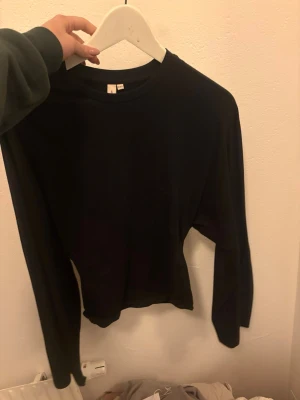 Svart tröja från Nelly  - Svart tröja från Nelly utsvängda armar och tajt i midjan.