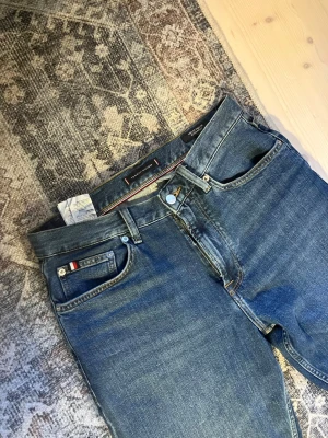 Tommy Hilfiger Jeans - Säljer ett par sprillans nya Tommy Hulfiger jeans. Har bara använts 1 gång men säljer för att de inte passade som jag ville och jag hade redan tagit bort lapparna😂. Fräsch jeans i en regular fit passform. Orginalpris ligger på cirka 1300kr. Hör av dig vid frågor eller funderingar!