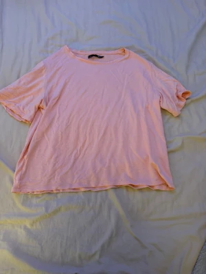 Ljusrosa t-shirt från 157 - Enkel och chill ljusrosa t-shirt från 157 i mjuk bomull. Klassisk passform med rund hals och korta ärmar. Perfekt till jeans eller shorts för en avslappnad vibe.