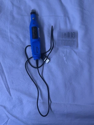 Elektrisk nagelfil med tillbehör - Det finns fyra olika bits med och ett bit som man behöver sandingbands till, allt är rengjort. Elektrisk nagelfil i blått med USB-sladd och fem olika metallborrar för slipning och formning av naglar. Perfekt för både manikyr och pedikyr hemma. Kompakt design och enkel att använda för snygga naglar.