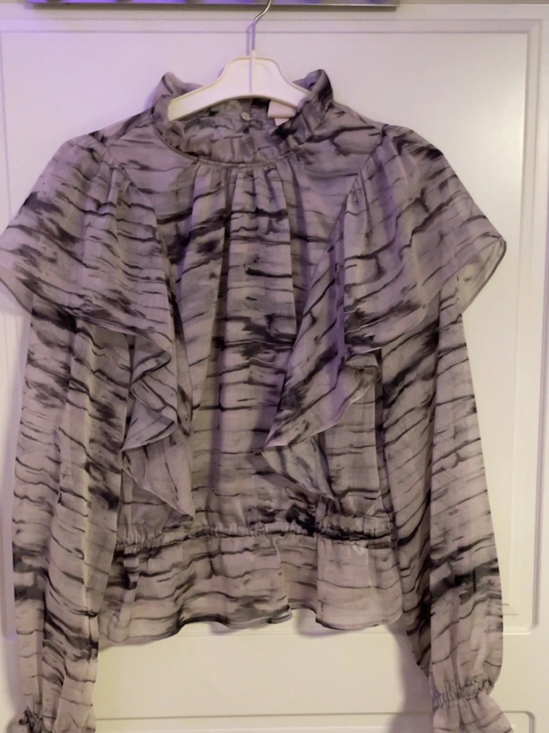 Gråmönstrad volangblus med hög krage