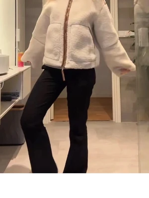 Beige teddyjacka från H&M - Supermjuk beige teddyjacka från H&M med bruna detaljer och dragkedja framtill. Jackan har stora fickor och en oversized passform som ger en chill vibe. Perfekt för att hålla sig varm och ändå se snygg ut under kyliga dagar. Skärmdumpar från min egna annons