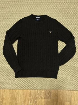 Svart kabelstickad tröja från Gant - Klassisk svart kabelstickad tröja från gant. Nytt skick 9,9/10 storlek M