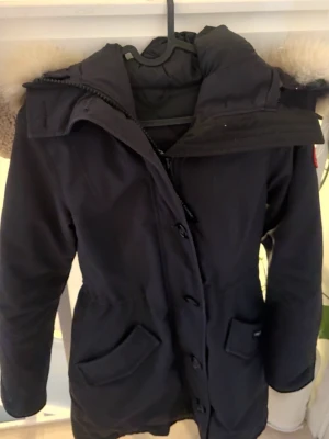 Rossclair parka Canada goose - Canada goose jacka som snatchar ens midja när man spänner fast den inifrån, passar bra till sånt här väder och är en snygg jacka till vardagen, den passar med allt, kvitto finns. 