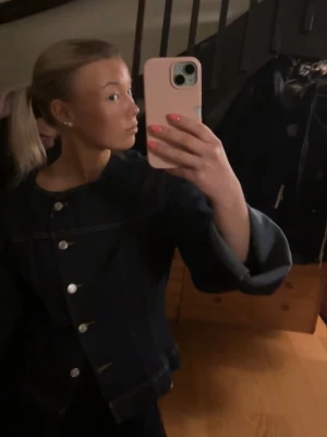 Mörkblå jeansjacka med vida ärmar - Säljer en mörkblå jeansjacka med snygga silvriga knappar framtill och vida ärmar. Jackan har en rak passform och klassiska sömmar som ger en cool look. Perfekt att slänga på sig över en t-shirt eller hoodie.