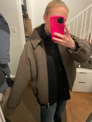 Mango Brun och beige rutig jacka med dragkedja - SLUTSÅLD MANGO JACKA, NY MED LAPP, PRIS KAN DISKUTERAS‼️Säljer en oversized rutig jacka i brunt och beige med dragkedja framtill och klassisk krage. Jackan har långa ärmar och ett avslappnat, loose fit. Perfekt för dig som gillar en trendig och bekväm stil.