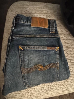 Blå jeans från Nudie Jeans - Säljer ett par jeans från nudie som är i archive stil, jeansen är vintage och en äldre modell som är svåra att få tag på! Priset kan diskuteras hör gärna av er för mer bilder✅