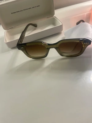 CHIMI 04 - Säljer ett par CHIMI solglasögon i modellen 04 och färgen grön. Allt har en väldigt fint skick, dock finns där lite defekter på påsen man har solglasögonen i men fodralet och servetten är också felfria. Nypris: 1250 kr