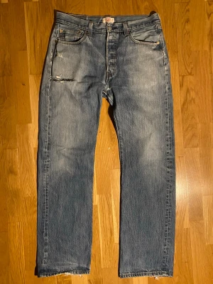 Vintage Levi’s jeans - Ett par snygga Levi’s 501 med väldigt fina slitningar och patina. De har ganska många små hål som jag kan skicka bild på om man vill. De är i storlek 34/34 som kan vara svårt att se på baklappen. Ifall nu har fler frågor eller vill ha fler bilder så skriv!