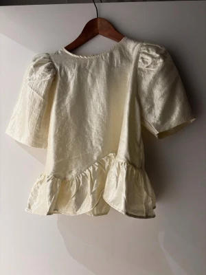 Blus från Gina Tricot  - Vit/lite guldig blus från Gina Tricot med puffiga armar. Aldrig använt. Storlek S