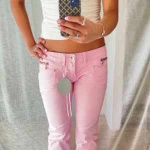 Ljusrosa bootcut jeans med detaljer - Så  fina lowaist bootcut jeans med jättefin detaljer på fickorna och knapparna! 🌸  Märke: Mayo Chix Färg: Ljusrosa 💝 Material: Denim   Midjemått: 38 cm Innerbenslängd: 78 cm  Vid frågor är det bara att höra av sig! 😊 Bundle = rabatt  💕 