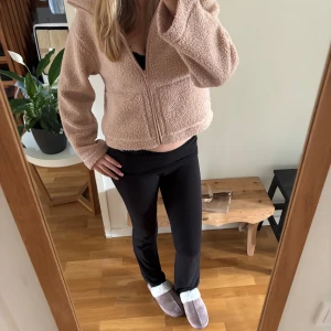 Beige teddyjacka med dragkedja - Mysig och  teddyjacka i beige med lång ärm och dragkedja framtill. Jackan har en fluffig och mjuk fleece-känsla, perfekt för chill dagar. Enkel design utan synliga detaljer förutom dragkedjan. Snygg att matcha med svarta leggings eller jeans. Passar från xs till m