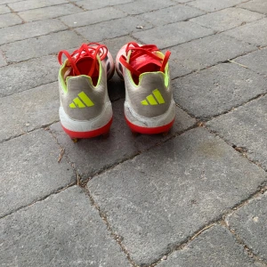 Adidas f50 PRO fotbollskor - Säljer ett par Adidas fotbollsskor med snygg design i rött, vitt och neon-gult. Skorna har svarta ränder på sidan, röda snören och dobbar för gräsplan. Ovandelen är i syntetmaterial och insidan är fodrad i neon-gult. Perfekta för dig som vill sticka ut på planen! Är använda i 4 månader. Bra kvalité lite smuts men dom är jättebra ändån.