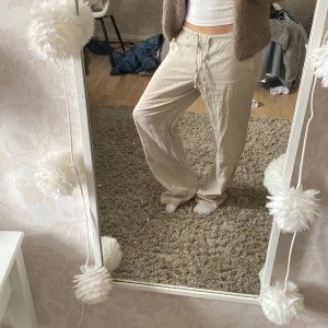 Beiga linnebyxor - Snygga och luftiga beiga linnebyxor med rak passform. Perfekta för varmare dagar och ger en chill vibe. Byxorna har elastisk midja och är tillverkade i ett tunt, svalt linnematerial. Linne byxorna är även helt oanvända då lappen fortfarande sitter kvar💕